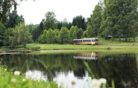 Der Goldene Triebwagen fährt entlang eines Waldviertler Teichs, © NÖVOG/knipserl.at